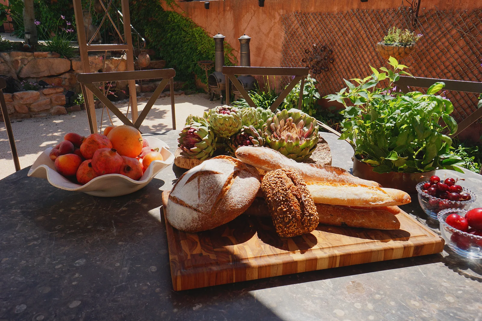 Pain frais, artichauts, fruits et herbes aromatiques sur la table de la bastide